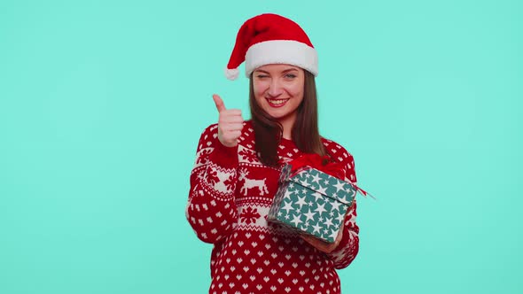 Joyful Girl in Red Christmas Sweater with Deers Presenting Christmas Gift Box Shopping Holiday Sale alt