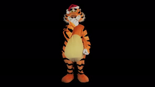 Man in Tiger Costume with Santa's Red Hat Yawns and Closes His Mouth with Paw alt