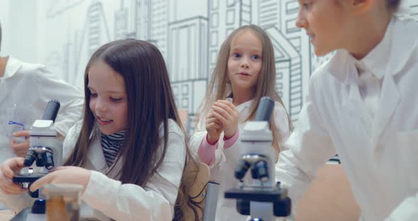 Teen at School Laboratory Studying Biology Looking Through Microscope alt