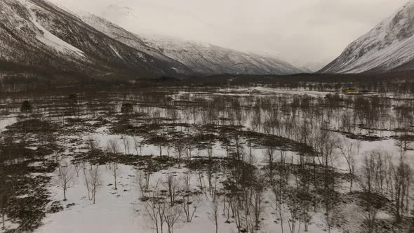 Aerial along snowy valley with freezing winter conditions, Signaldalen alt
