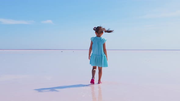 Little Girl Goes Along Surface of Salt Lake alt
