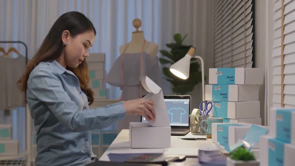 Asian small business owner woman entrepreneur work packing delivery. alt