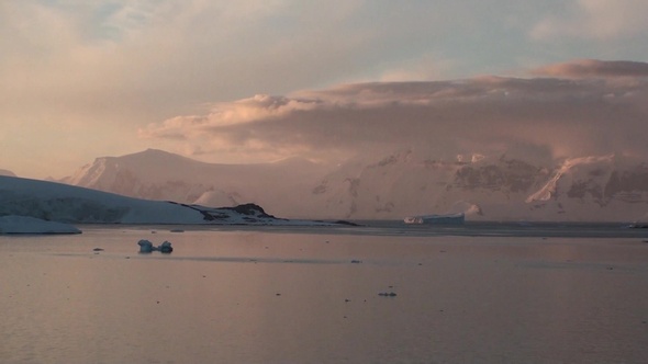 Sunset in Antarctica, with calm sea water. alt