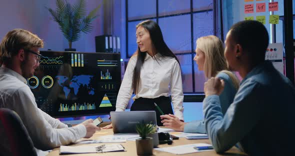 Asian Female Worker Explaining Presentation on Digital Map with Statistis Datas alt