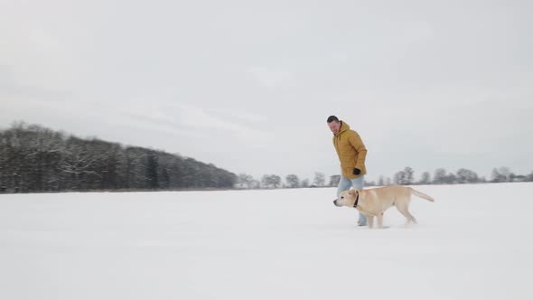 Man Walking With His Dog In Snowy Landscape 