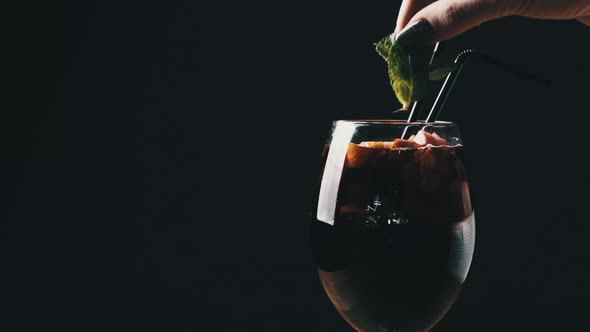 Mulled Wine in a Glass with Straws in Restaurant on Black Background alt