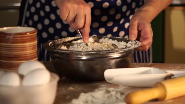 Close Up Shot of Housewife's Hands Who Mixes the Flour with Water Eggs for Dough alt