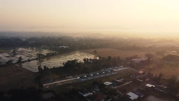 Establishing Aerial View Shot of sunrise with fog above asia village