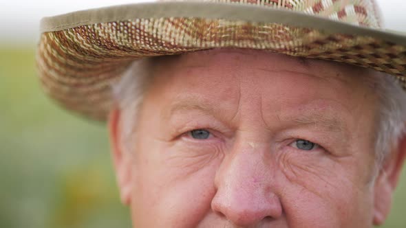 Close Up Portrait of Old Man Looking to the Camera in the Field Background alt