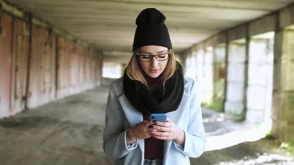 Girl hitchhiking with backpack through city streets and underground passages. alt