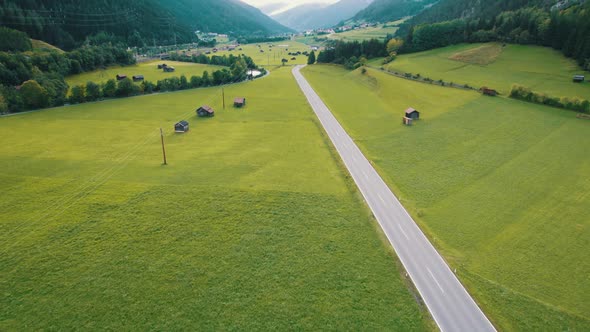 Empty Road in Austrian Valley Between Green Fields in the Alps Aerial View alt