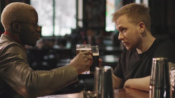Multi-Ethnic Male Friends Drinking Beer At Bar alt