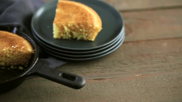 Slice of sweet cornbread with honey on the plate alt