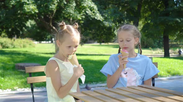 Little Girls Eating Ice-cream Outdoors at Summer in Outdoor Cafe