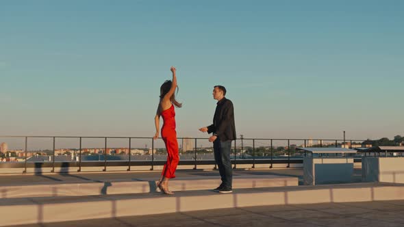 Couple in Love on a Romantic Date Dancing on the Roof of a Building at Sunset
