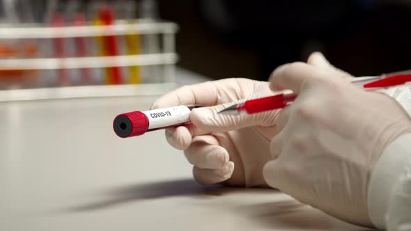 Scientist Marking COVID-19 Test Tube