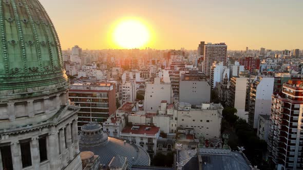 Aerial dolly out flying over Balvanera neighborhood revealing Argentine Congress building at sunset, alt