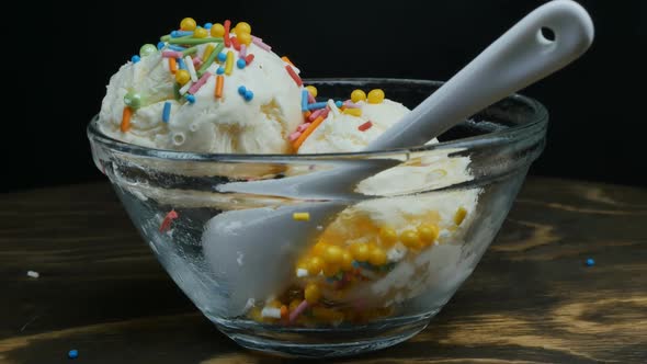 Closeup Sprinkle Large Balls of White Vanilla Ice Cream with Colorful Decorations in a Glass Bowl