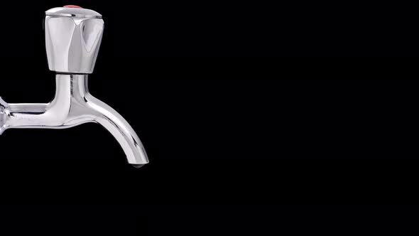 Water Slowly Dripping From a Chrome Tap, on a Black Background alt