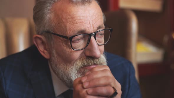 Portrait of Serious Pensive Old Male In Formal Blue Suit alt