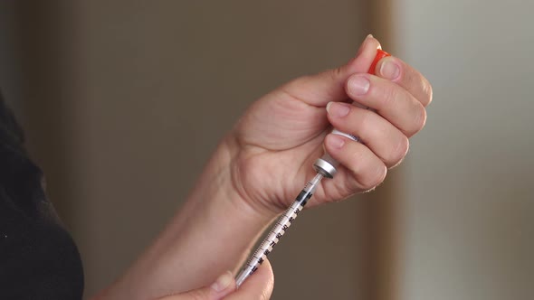 Woman with a Syringe and Insulin in Hand Closeup alt