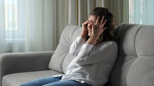 Disabled Woman Suffers From Headache Sitting on Sofa at Home alt