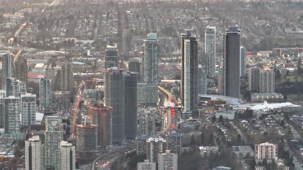 Aerial truck left of highway traffic, Sky Train and Brentwood Town Centre skyscrapers in Burnaby cit alt