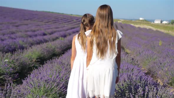 Girls in Lavender Flowers Field at Sunset in White Dress