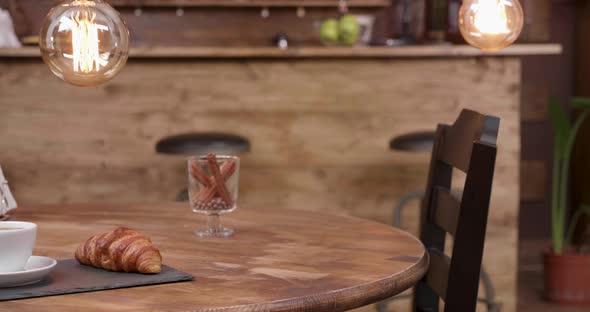 Close Up Revealing Shot of a Cup of Espresso Americano and French Croissant alt