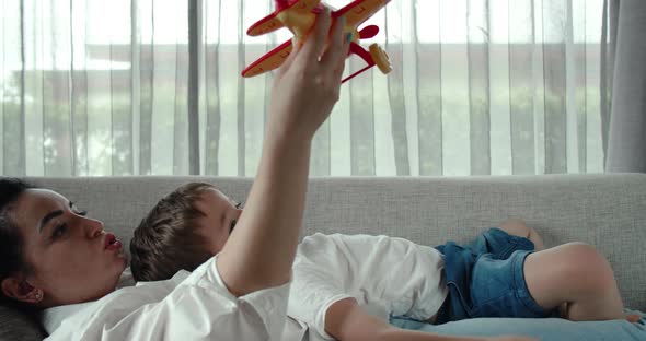 Carefree Loving Family of Two Mom with Her Son Little Preschooler Playing with a Toy Airplane with alt