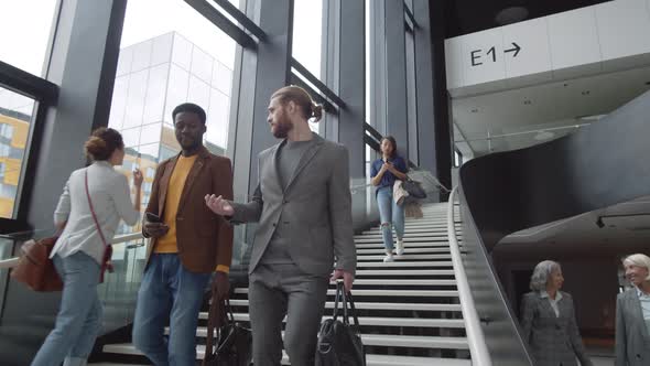 African and Caucasian Men Having Talk in Airport alt