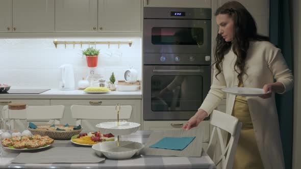 Woman Setting the Table for Family Celebration Dinner in the Kitchen alt