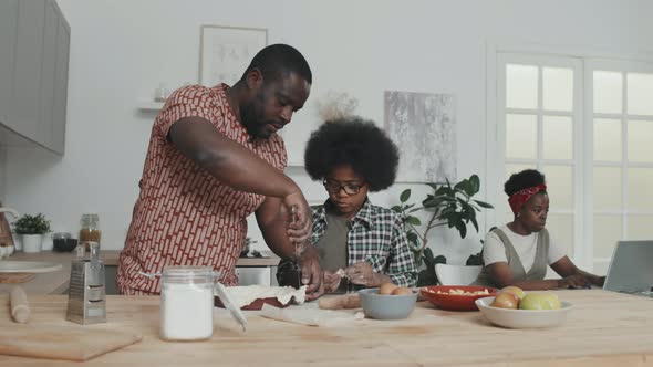 Father and Son Making Apple Pie Together at Home alt