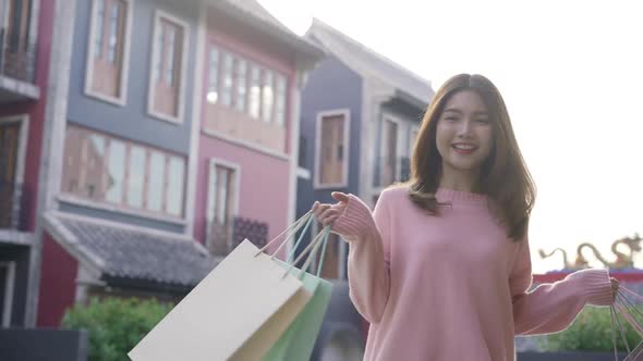 Beautiful shopaholic female holding shopping bags while walking for shopping outdoor alt