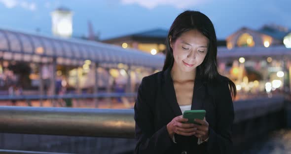 Business Woman Reading on Mobile Phone at Night  alt