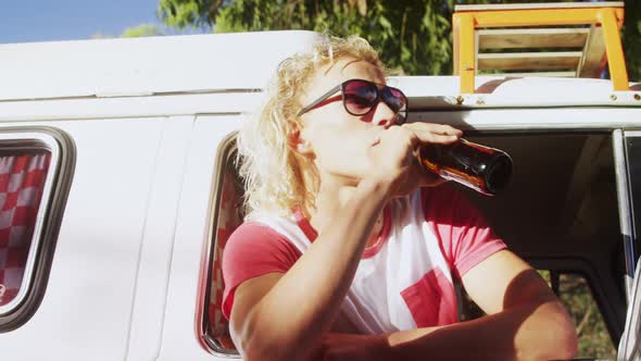 Man sitting in van and drinking beer 4k alt