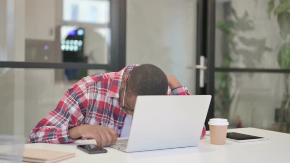 Tired African Man Taking Nap While Sitting in Office with Laptop alt