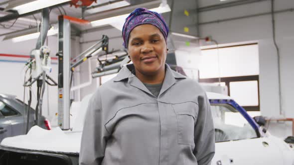African American female car mechanic looking at the camera and smiling alt