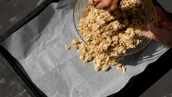 Homemade granola with nuts and fresh berries. Female hands prepare muesli on the table alt