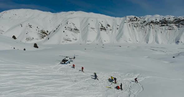 Skiers and snowboarders go to the Helicopter in the winter mountains alt