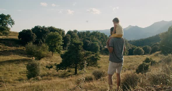 Father holding his daughter on neck and walk on hike journey to mountain alt