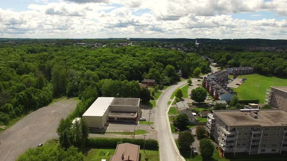 Aerial tracking shot with small town seen in the distance. alt