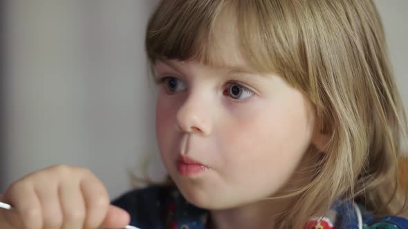 Portrait of a Little Girl Eating Pasta and Smiling