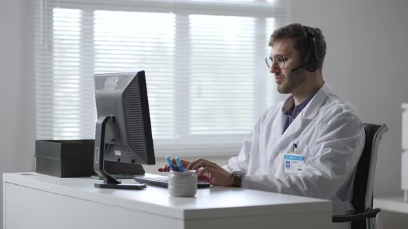 Male Doctor or Nurse with Headset and Computer Working at Hospital alt