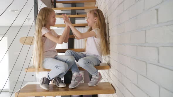 Twins Gossiping on Steps at Home