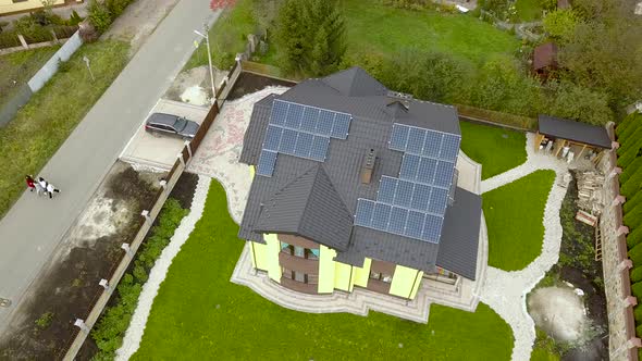 Aerial view of a rural private house with solar photovoltaic panels for producing clean electricity alt