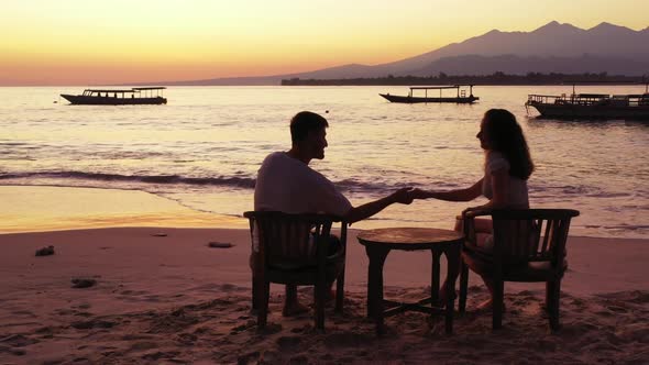 Young couple sunbathe on exotic tourist beach holiday by transparent water with white sandy backgrou alt