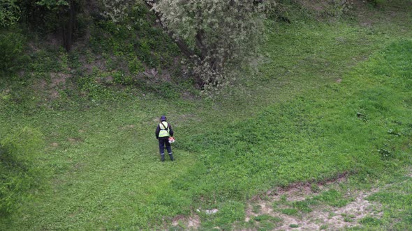Timelapse: two men mow grass with trimmers. 4K alt