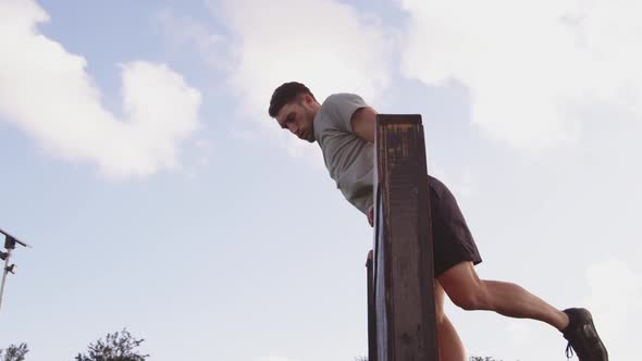 Young man training at an outdoor gym bootcamp alt