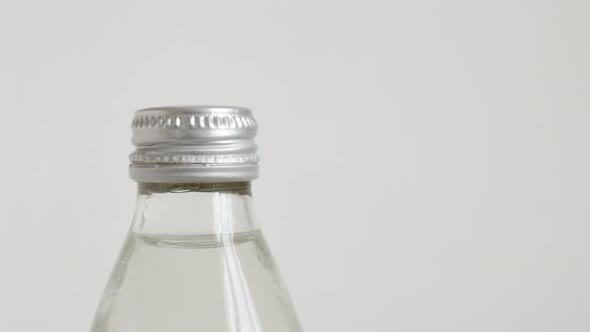 Transparent water bottle on white slow tilt 4K video